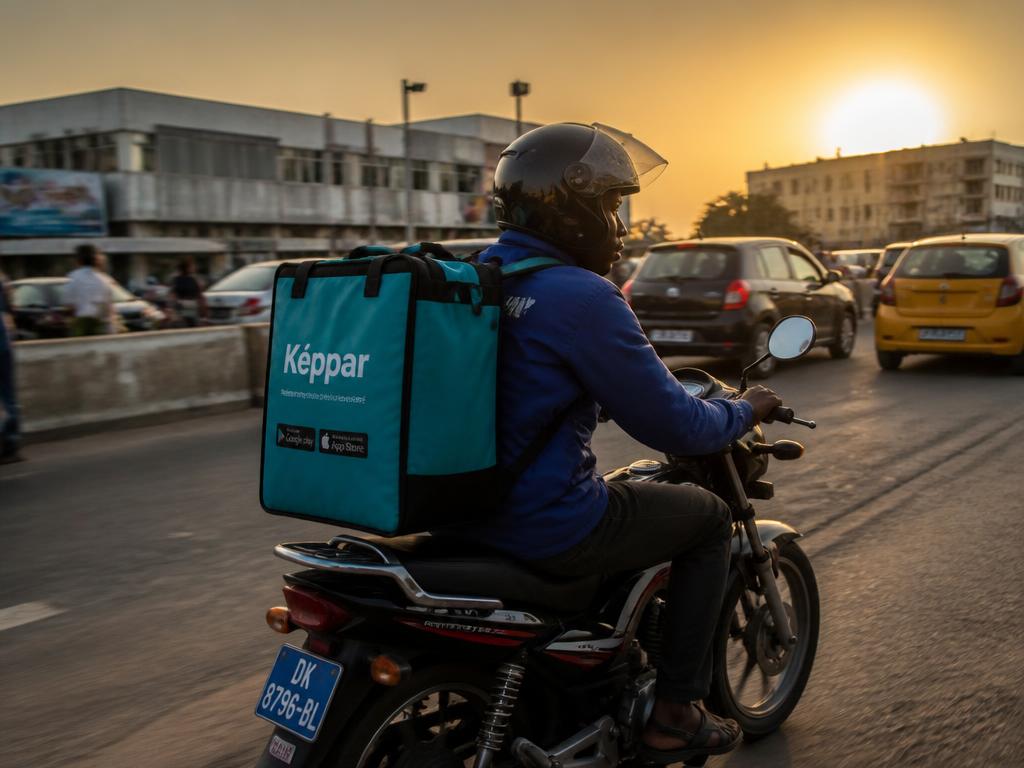 Livreur à moto ALINEA 221 en route dans les rues de Dakar